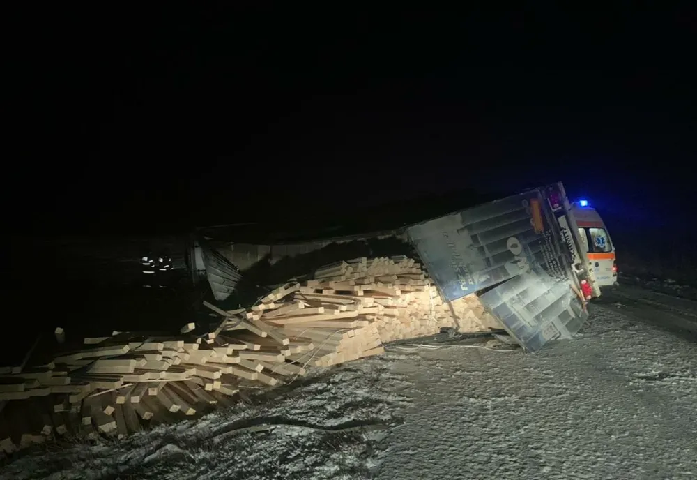 Autocamion încărcat cu cherestea, răsturnat în afara părții carosabile