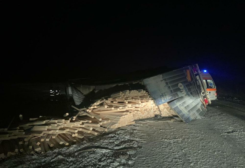 Autocamion încărcat cu cherestea, răsturnat în afara părții carosabile